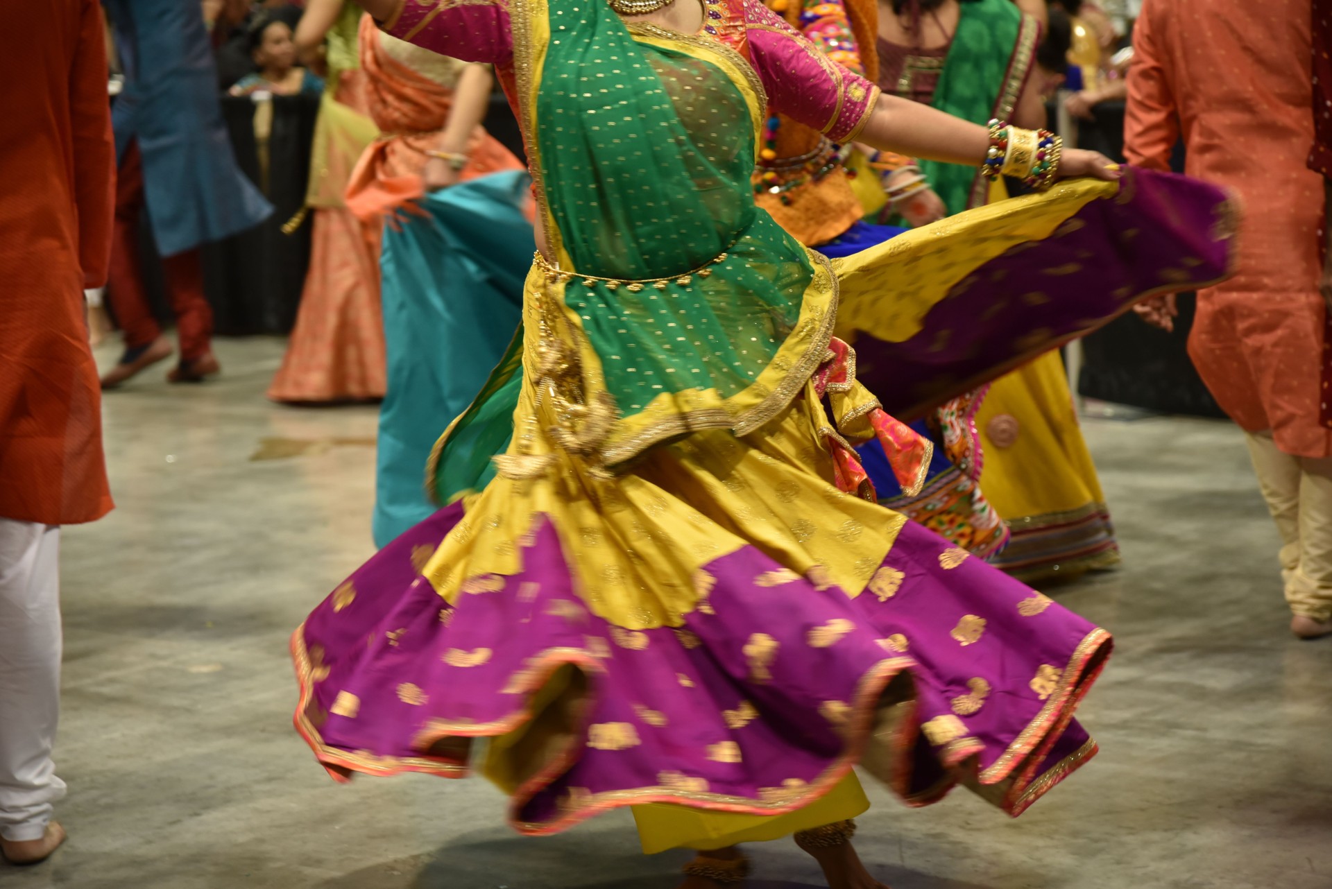 Abstract of dancing girls and women in colorful costumes with motion effect during the navratri festival celebration.